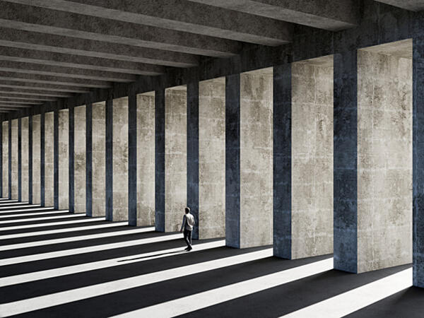 Man wlaking past concrete pillars